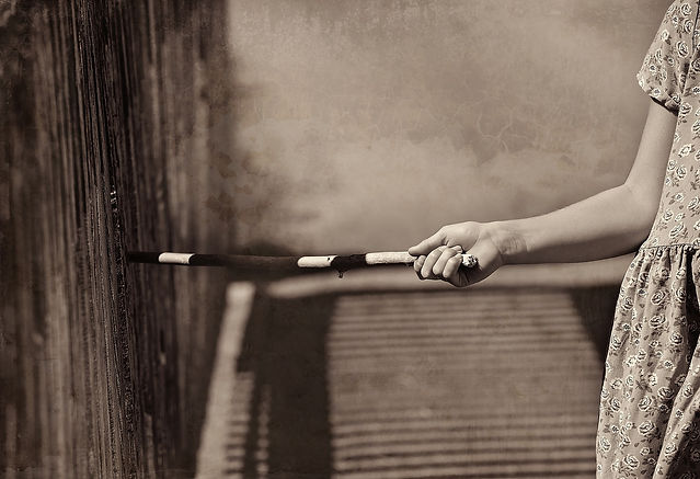 A child running a stick along a wooden fence